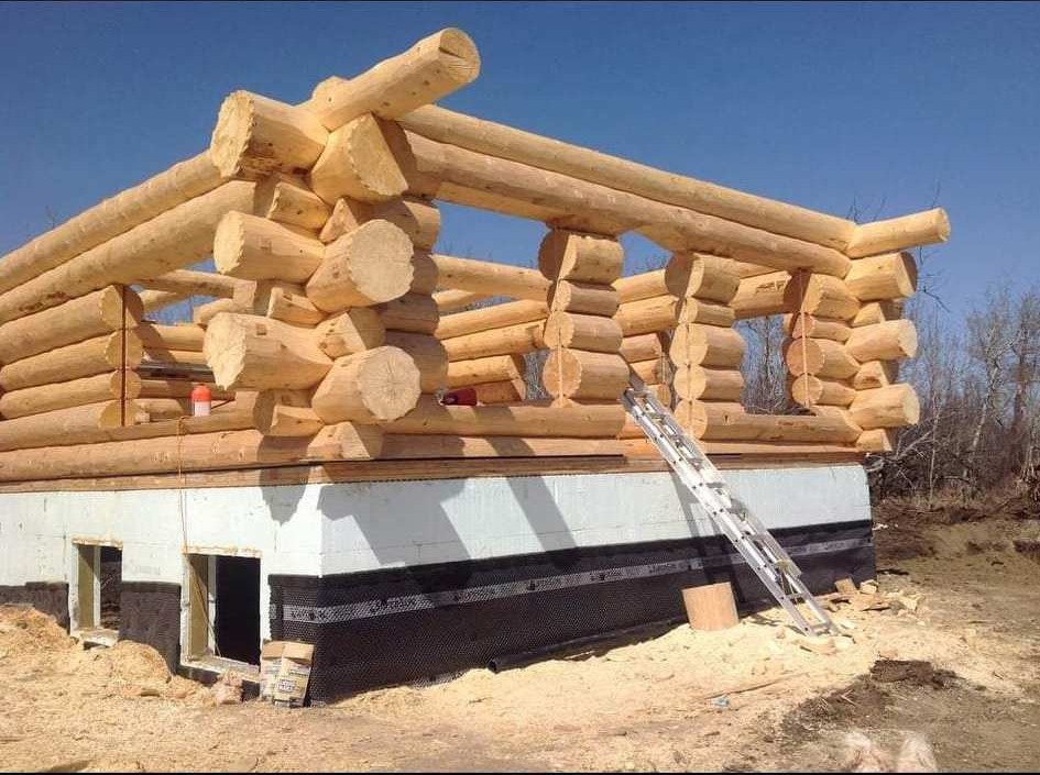 Large log shell under construction on a foundation